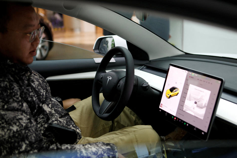 A visitor checks a Tesla Model 3 car at a showroom of the U.S. electric vehicle (EV) maker in Beijing, China February 4, 2023. REUTERS/Florence Lo