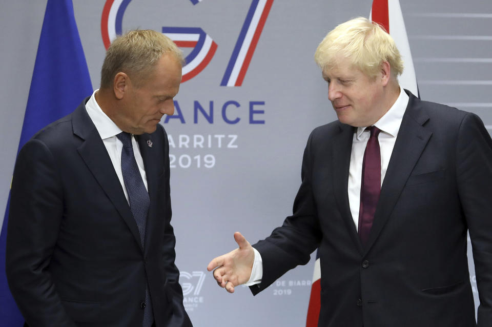 Britain's Prime Minister Boris Johnson, right, reaches out to shakes hands with President of the European Council Donald Tusk before a meeting on the side of the G-7 summit in Biarritz, France Sunday, Aug. 25, 2019. (AP Photo/Markus Schreiber)