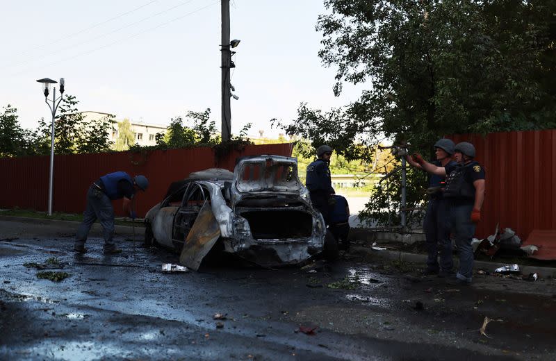 Agentes de policía trabajan junto a un coche destruido tras un ataque militar ruso en Járkov