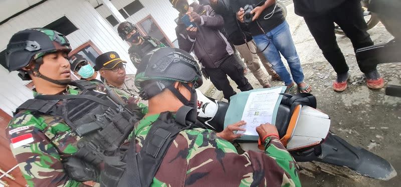 Indonesian security forces sign release forms for family members collecting the bodies of the Bagau brothers at the Sugapa health clinic in Intan Jaya regency, Papua