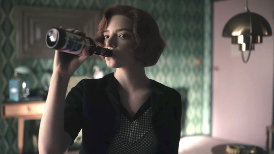 Anya Taylor-Joy as Beth Harmon drinks a bottle of beer in "The Queen's Gambit"
