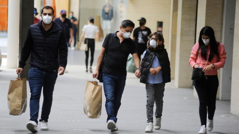 Mexicanos con bolsas caminando