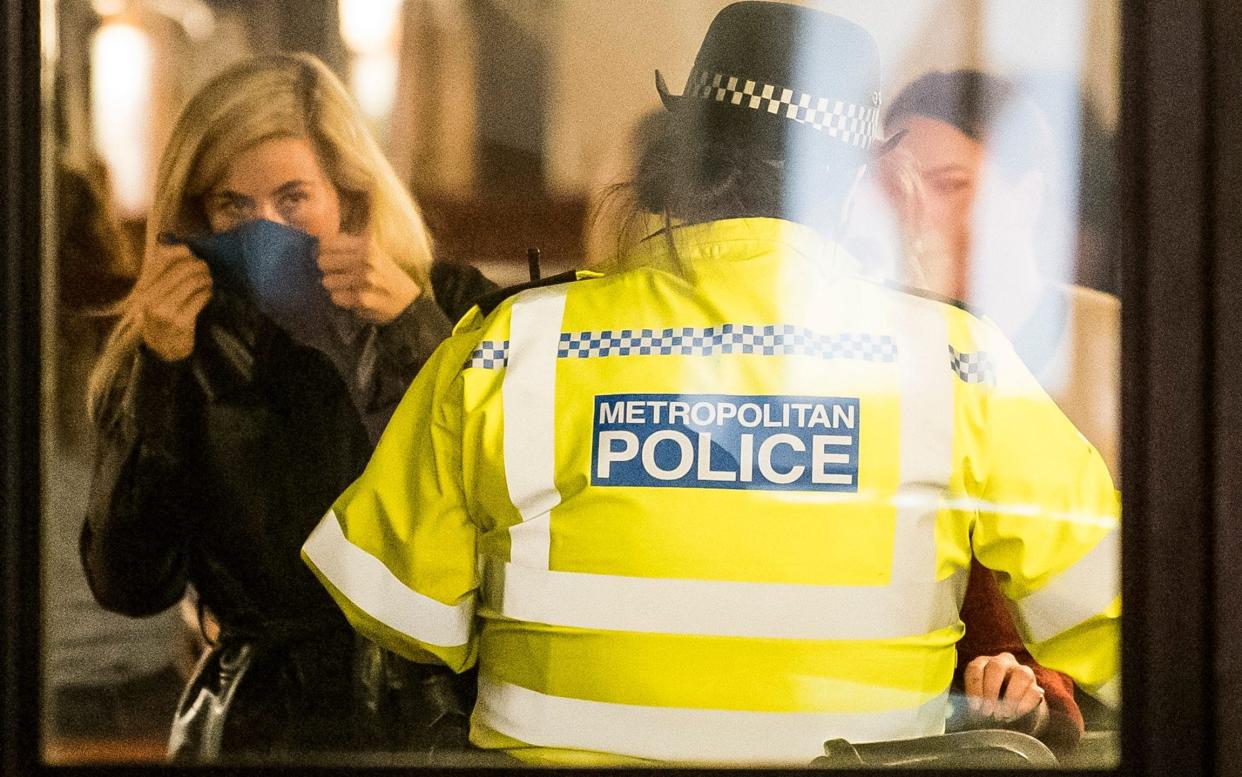 A police officer enters a bar on Portobello Road in Notting Hill, London on Friday night to ask members of the public to leave - Ben Cawthra/LNP