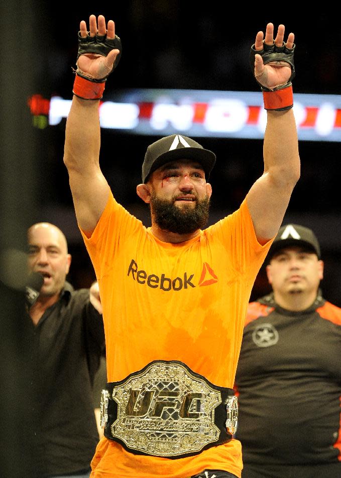 Johny Hendricks celebrates after beating Robbie Lawler during a UFC 171 mixed martial arts welterweight title bout, Saturday, March 15, 2014, in Dallas. Hendricks won by decision. (AP Photo/Matt Strasen)