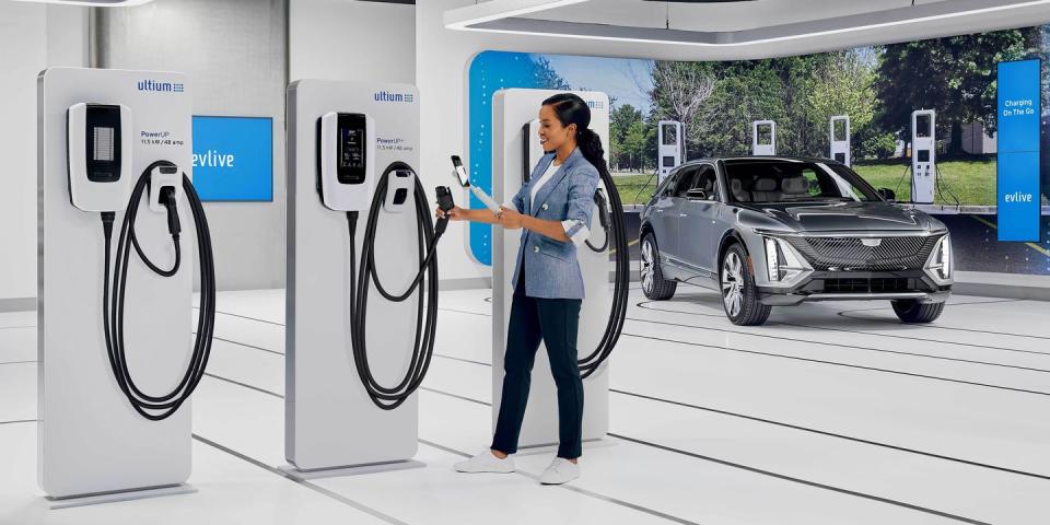 an ev specialist takes a video call on a mobile device in gm’s ev live studio, sharing video of ultium ev charging stations