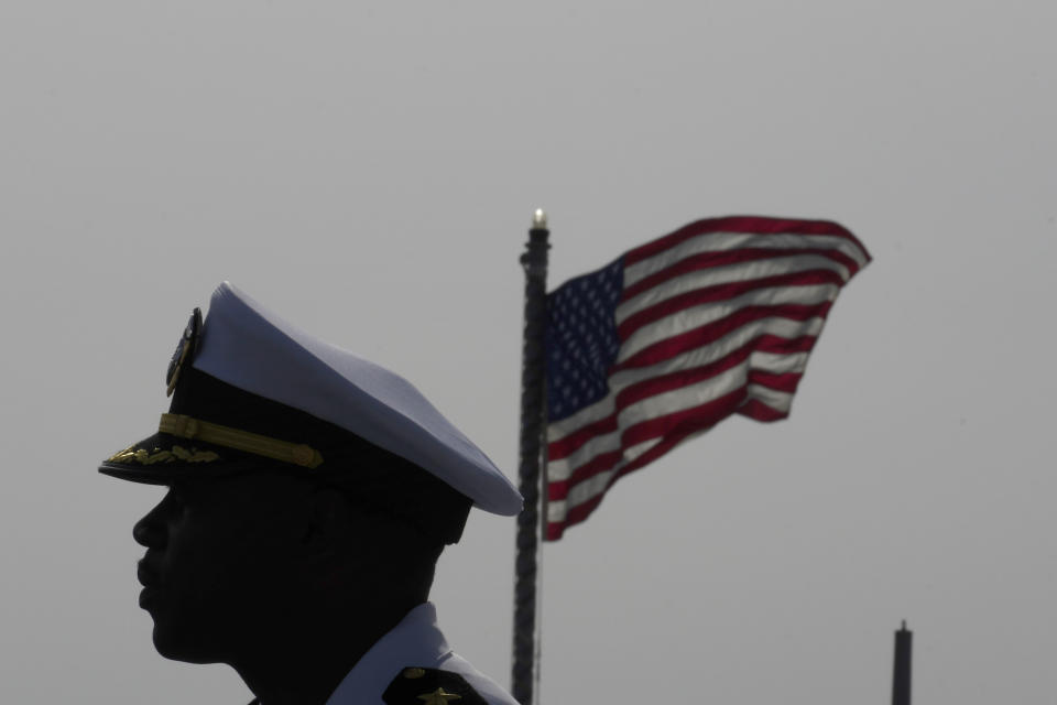 Cmdr. Executive Officer Tyrchra Bowman stand in front of U.S flag on the missile destroyer USS Arleigh Burke, docked in the port in southern city of Limassol, Cyprus, Wednesday, May 17, 2023. (AP Photo/Petros Karadjias)