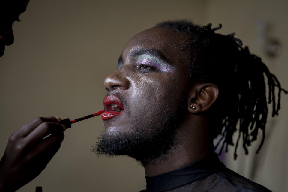 In this photo taken Thursday, June 11, 2020, Raymond Brian, a Ugandan refugee and a nonconforming gender person who also goes by the name of “Mother Nature,” has makeup done in a house that serves as a shelter for LGBT refugees in Nairobi, Kenya. Although Kenya is seen as a haven for LGBT refugees, they still face discrimination and even violence. (AP Photo/Brian Inganga)