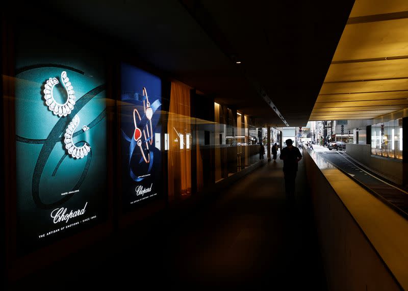 A man walks past signboard of luxury brands at a shopping mall in Tokyo in Tokyo