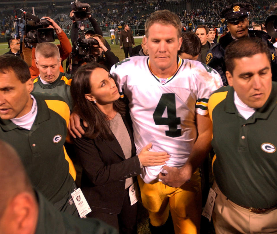 <p>Green Bay Packers quarterback Brett Favre is escorted off the field with his wife, Deanna, after the Packers defeated the Oakland Raiders 41-7, Monday, Dec. 22, 2003 in Oakland, Calif. Favre’s father passed away on Sunday. (AP Photo/Paul Sakuma)</p>