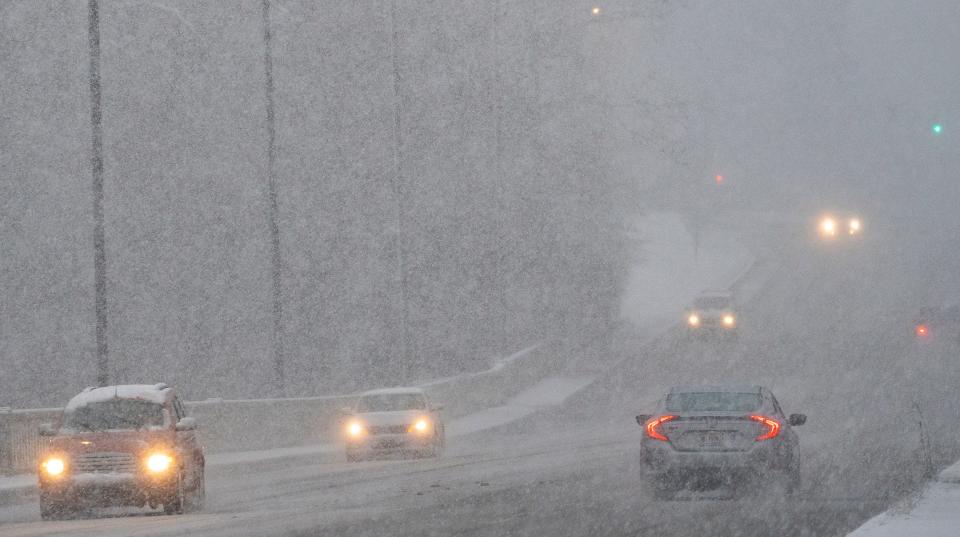 Snow flakes are heavy on Michigan Road, but accumulation still slight during the start of a snow storm Wednesday, Jan. 25, 2023 in Indianapolis, Ind. Temperatures hover around freezing as the slushy snow hits the ground.