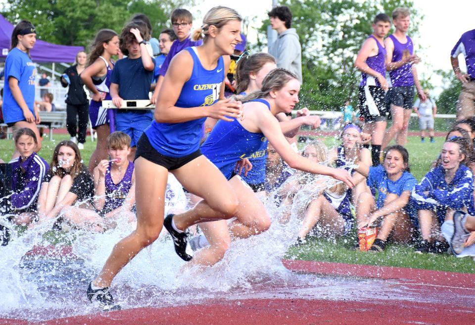 A trio of Cazenovia runners splash their way through the water hazard on the 2,000-meter steeplechase course in Little Falls at Section III's Class B2 championship meet Thursday. Cazenovia's boys and girls swept the team titles.