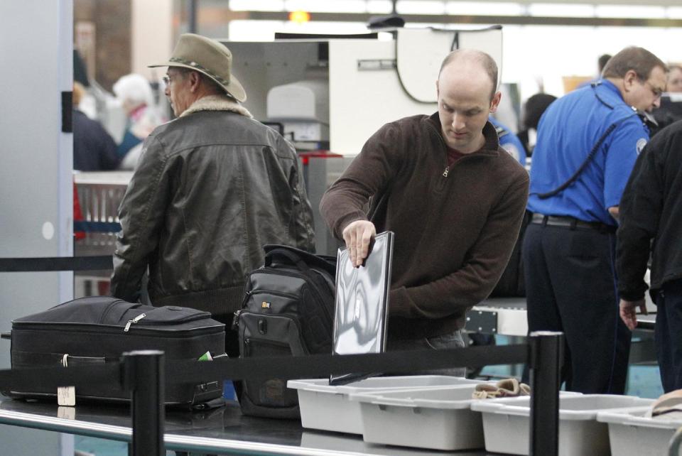 This April 30, 2012, photo shows a traveler passing through a security check point at Portland International Airport, in Portland, Ore. Airport security procedures, with their intrusive pat downs and body scans, don’t need to be toughened despite the discovery of a new al-Qaida airline bomb plot using more sophisticated technology than an earlier attempt, congressional and security officials said Tuesday. (AP Photo/Rick Bowmer)