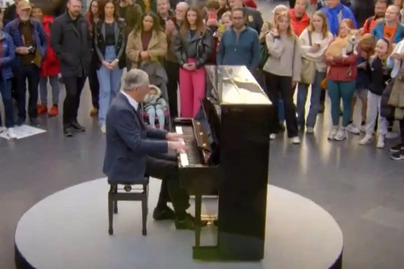 Man playing piano in train station
