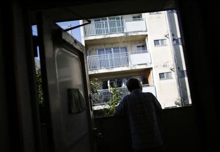 Resident Kohei Jinno, 79, looks out from his room at Kasumigaoka apartment complex, which is located near the National Olympic Stadium in Tokyo September 18, 2013. REUTERS/Issei Kato