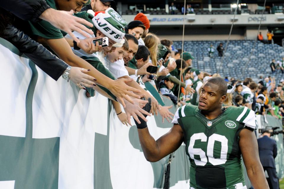 Former New York Jets left tackle D'Brickashaw Ferguson (60) reacts with fans after a game against the Cleveland Browns on Dec. 22, 2013, in East Rutherford, N.J.