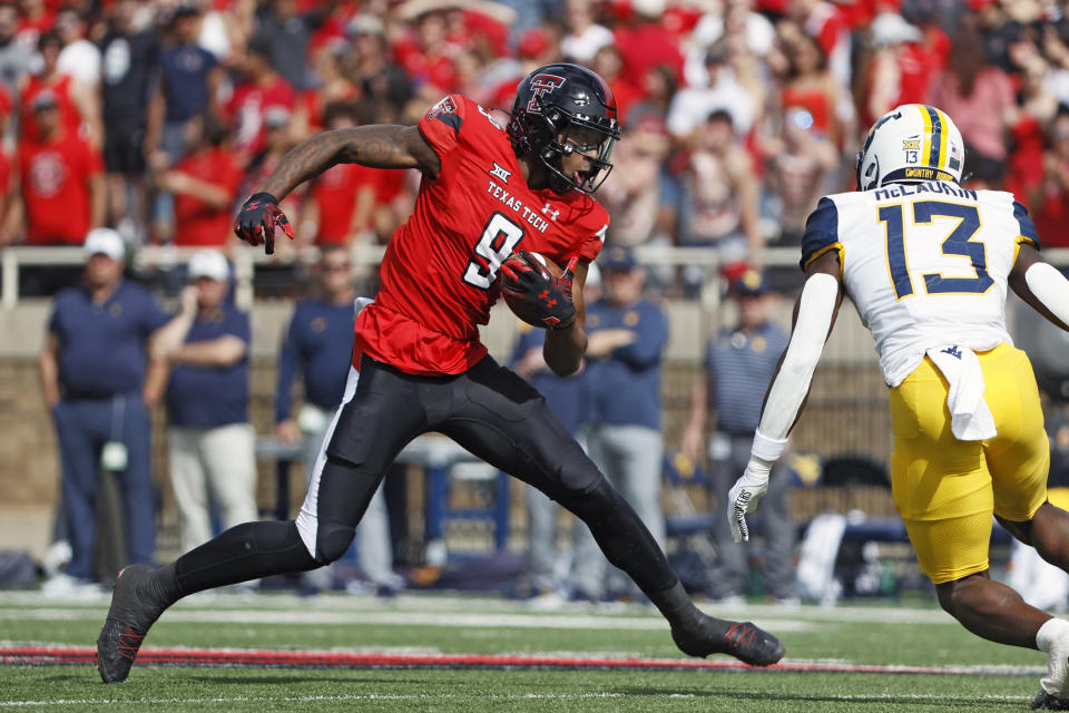 Texas Tech's Jerand Bradley (9) catches the ball around West Virginia's Hershey McLaurin (13) during the first half of an NCAA college football game Saturday, Oct. 22, 2022, in Lubbock, Texas. (AP Photo/Brad Tollefson)