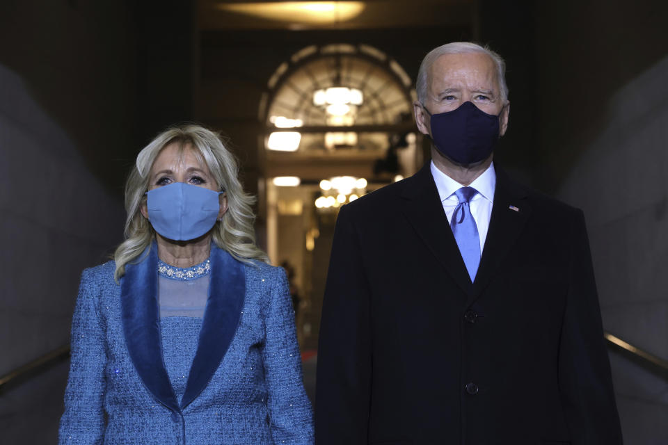 Joe Biden y su esposa Jill Biden avanzan juntos hacia el espacio del Capitolio en la ceremonia de toma de posesión de 2021. (Win McNamee/Pool Photo via AP)
