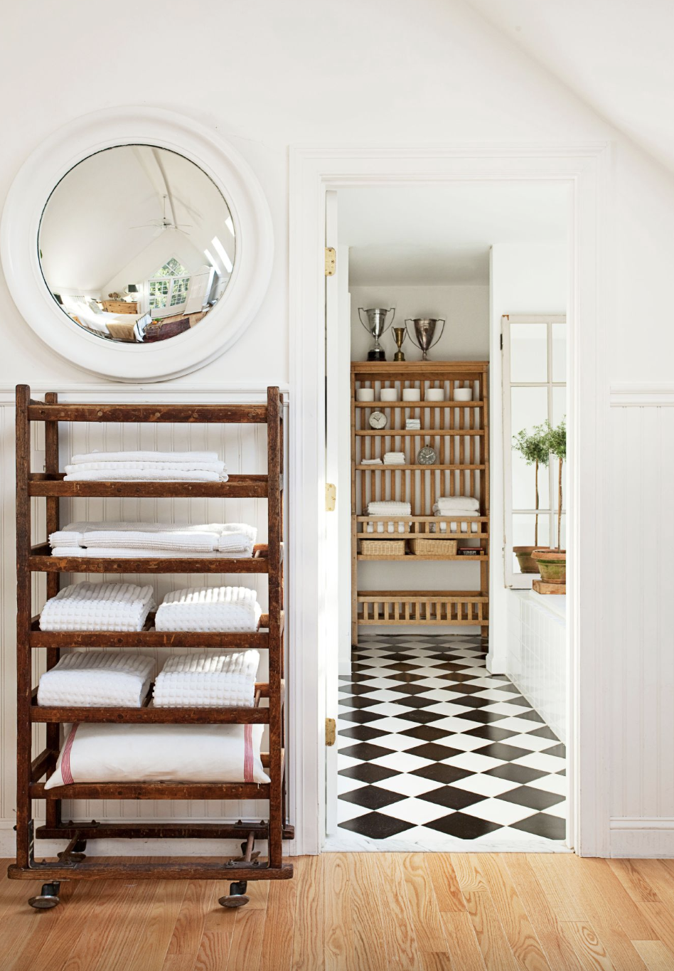 bathroom storage ideas, white towels folded on shelves next to the bathroom entrance