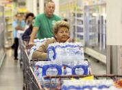 Customers stand in line to pay for cases of water at an H-E-B store Thursday, Dec. 15, 2016, in Corpus Christi, Texas. The city is warning its 320,000 residents not to use tap water because it might be contaminated with petroleum-based chemicals, prompting a rush on bottled water and the closure of local schools. (Gabe Hernandez/Corpus Christi Caller-Times via AP)