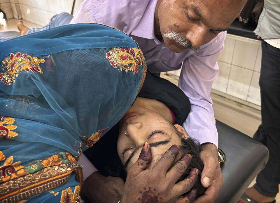 A couple try to pacify their daughter suffering from heat related ailment as she is brought to the government district hospital in Ballia, Uttar Pradesh state, India, Monday, June 19, 2023. Several people have died in two of India's most populous states in recent days amid a searing heat wave, as hospitals find themselves overwhelmed with patients. More than hundred people in the Uttar Pradesh and dozens in neighboring Bihar have died due to heat-related illness. (AP Photo/Rajesh Kumar Singh)