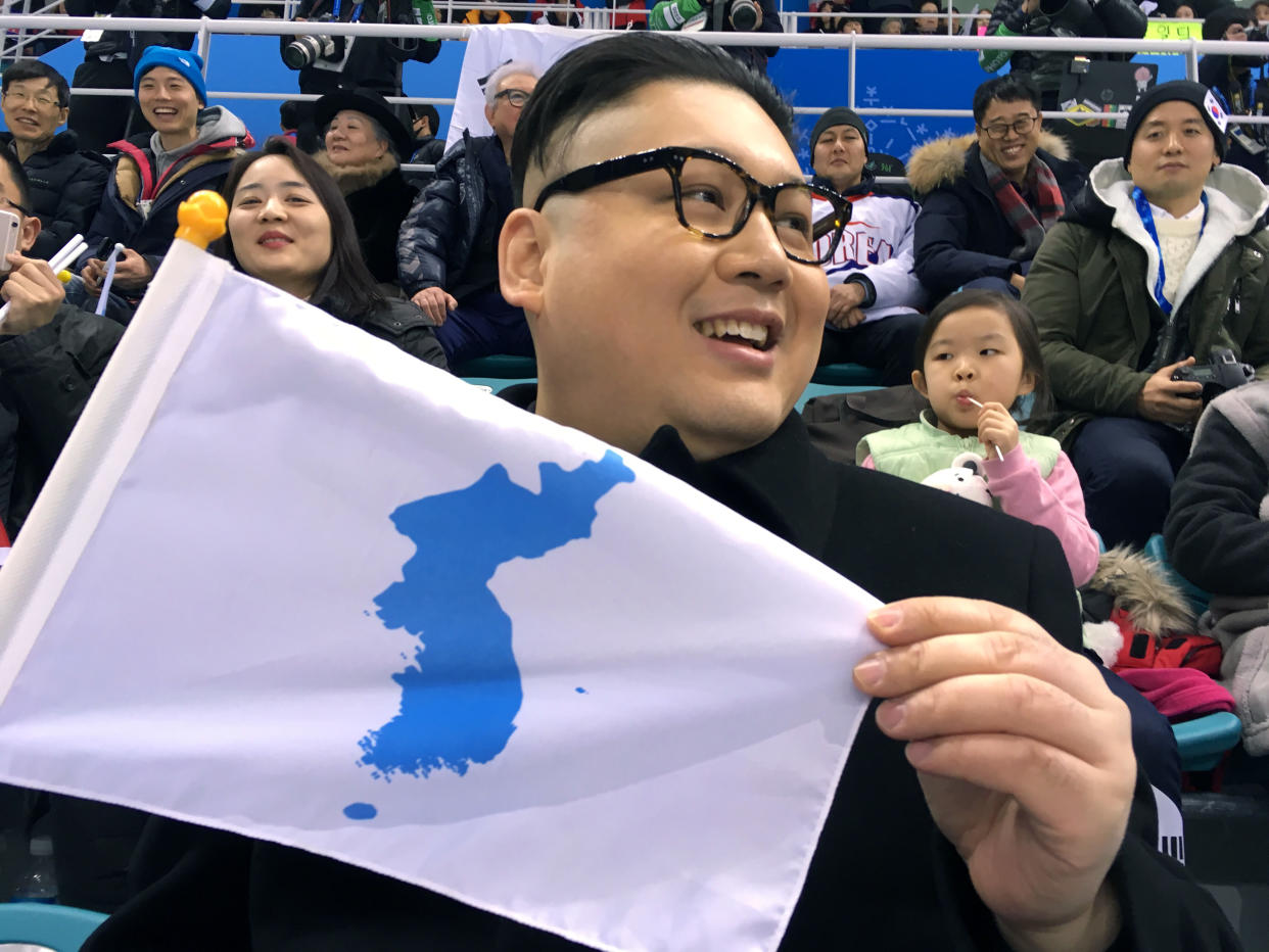 A Kim Jong Un impersonator, calling himself only Howard from Australia, holds a unification flag while attending the Korea-Japan women’s ice hockey game at the 2018 Winter Olympics in Pyeongchang, South Korea on Wednesday. (AP)