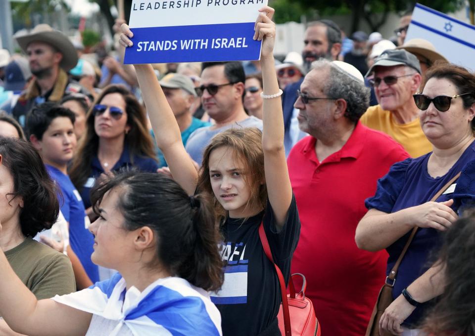 A demonstrator holds a sign Sunday afternoon during a pro-Israel rally to express solidarity with the Jewish state after the Oct. 7 attack by Hamas. About 200 people attended the event.