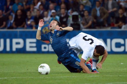 French midfielder Mathieu Valbuena (L) collides with Uruguayan midfielder Walter Gargano during a friendly match at the Oceane stadium in Le Havre, western France. The match ended in a 0-0 draw