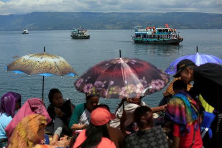 Rescue team members during an operation, as relatives of the missing passengers after a ferry sank earlier this week in Lake Toba, are waiting at Tigaras port in Simalungun, North Sumatra, Indonesia, June 22, 2018. REUTERS/Beawiharta