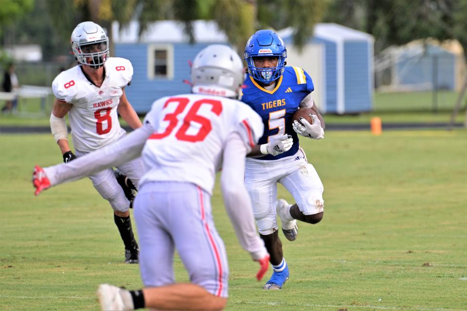 Martin County’s Tony Colebrook stares down a defender as he finds room in an open-field run against Seminole Ridge (Aug. 18, 2023).