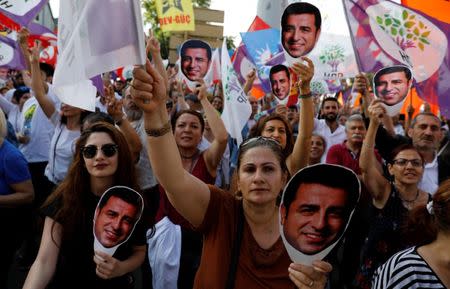 Supporters of Turkey's main pro-Kurdish Peoples' Democratic Party (HDP) hold masks of their jailed former leader and presidential candidate Selahattin Demirtas during a rally in Ankara, Turkey, June 19, 2018. REUTERS/Umit Bektas