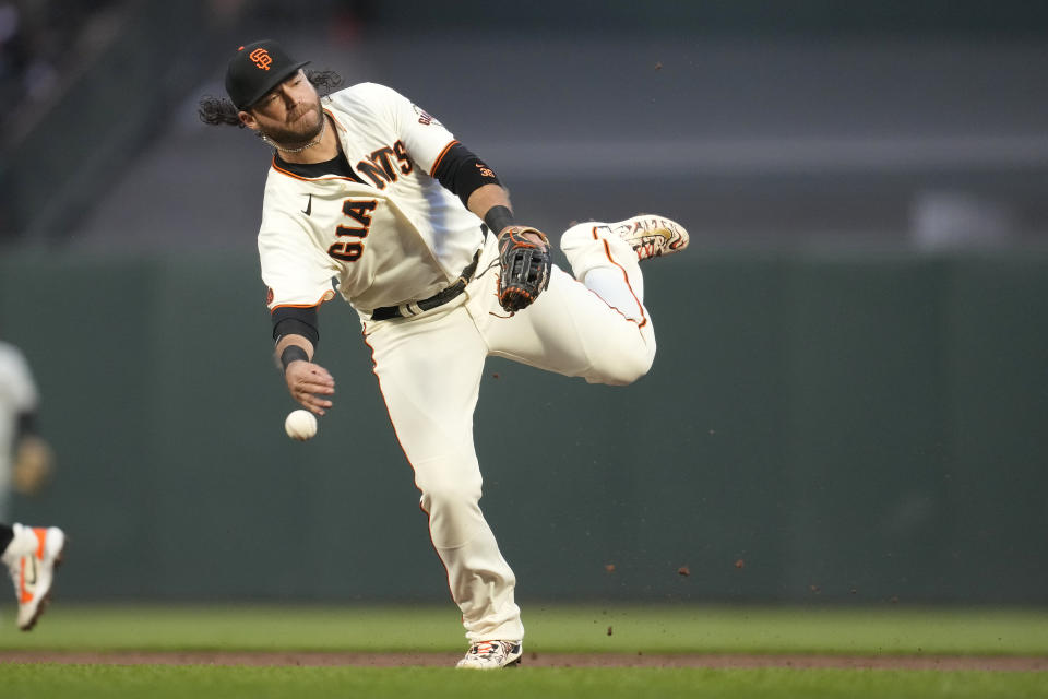 San Francisco Giants shortstop Brandon Crawford makes a throwing error that allowed Los Angeles Dodgers' Mookie Betts to advance to third base on single hit by Freddie Freeman during the third inning of a baseball game in San Francisco, Monday, April 10, 2023. (AP Photo/Jeff Chiu)