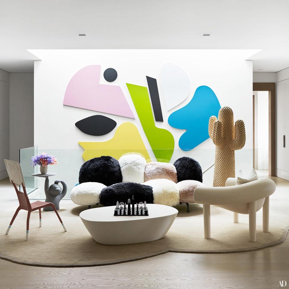 A child’s chair by Lucas Maassen (left), sofa by the Campana Brothers, and armchair by Konstantin Grcic form a sitting area on the second floor. Artworks by AC Group (on wall) and Gufram.