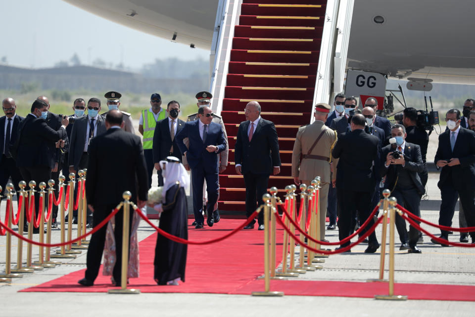 Iraqi President Barham Salih, center right, welcomes Egyptian President Abdel Fattah el-Sissi, center left, upon his arrival at Baghdad Airport, Iraq, Sunday, June 27, 2021. (AP Photo/Khalid Mohammed)