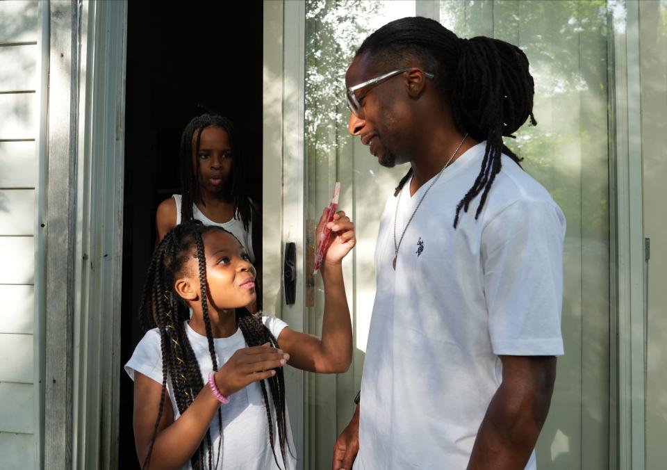 Brandon Woodson, 32, talks to his daughter Baylie Woodson, 10, and Brandon Woodson Jr., 13, on June 15, 2022, at his home in Indianapolis.