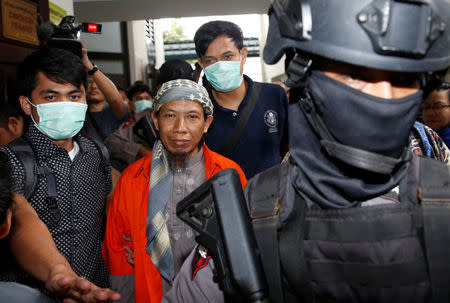 Policemen guard Islamic cleric Aman Abdurrahman during his walk to the courtroom for his trial in Jakarta, Indonesia February 15, 2018. REUTERS/Beawiharta