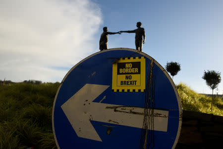 FILE PHOTO: A ' No Border, No Brexit' sticker is seen on a road sign in front of the Peace statue entitled 'Hands Across the Divide' in Londonderry, Northern Ireland, January 22, 2019. REUTERS/Clodagh Kilcoyne/File Photo