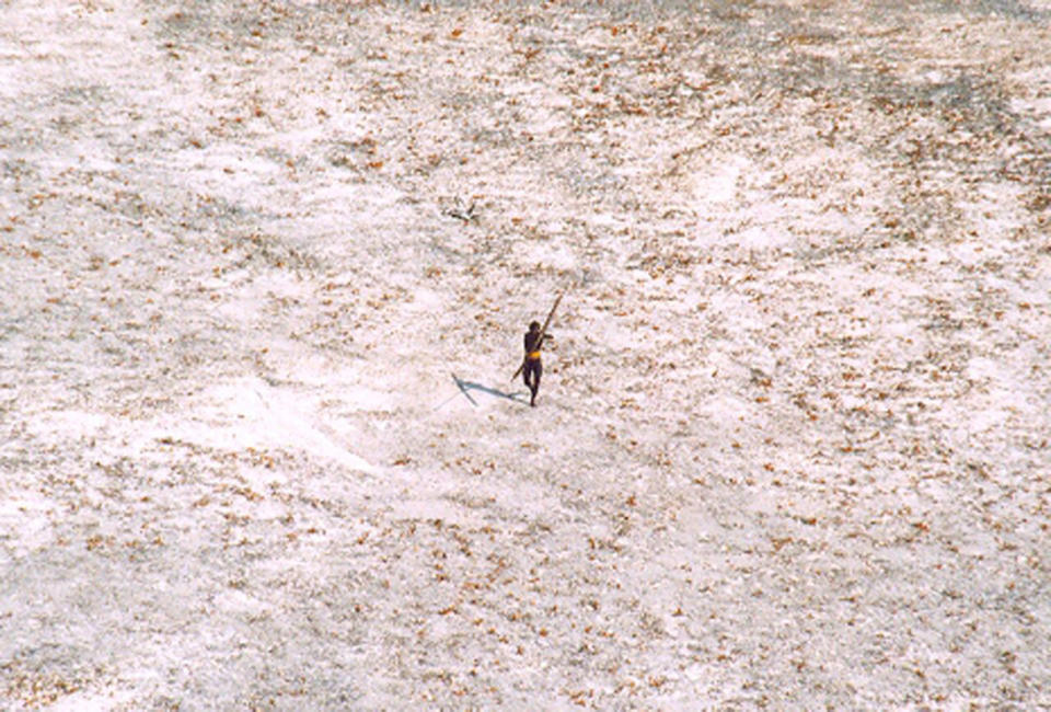 A Sentinel tribal man aims with his bow and arrow at an Indian Coast Guard helicopter on December 28, 2004.