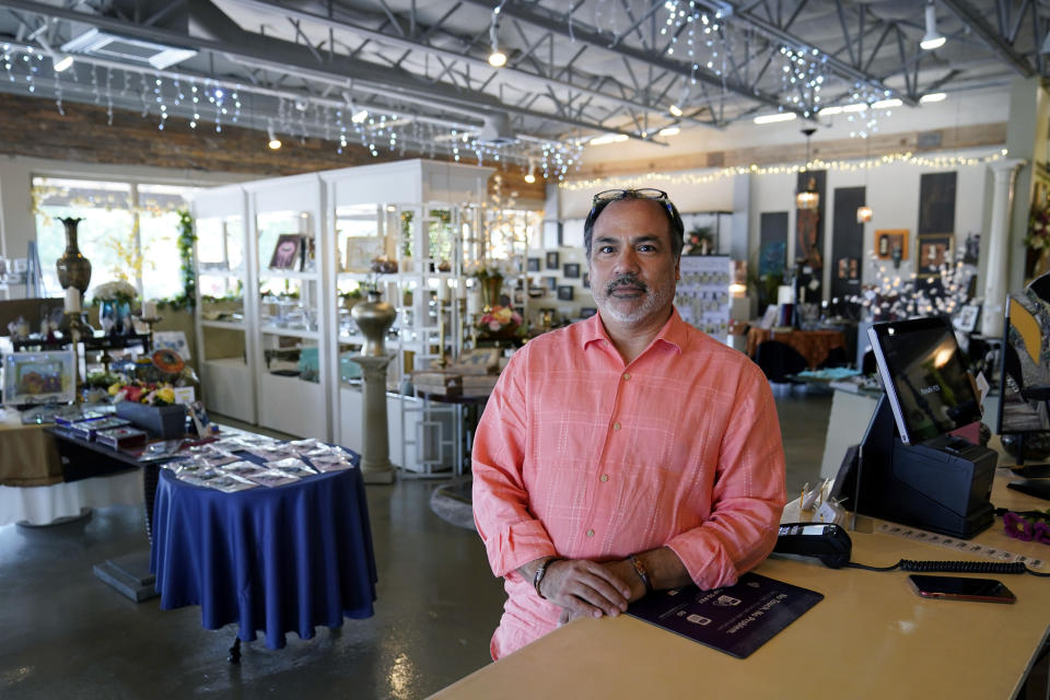 Martin Garcia, owner of gift and décor store Gramercy Gift Gallery, poses for a photo at his shop, Wednesday, June 29, 2022, in San Antonio. Landlords were forgiving about rent during the first two years of the pandemic, but now many are asking for back due rent. Meanwhile, most of the government aid programs that helped small businesses get through the pandemic have ended. (AP Photo/Eric Gay)