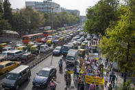 Student activists carry posters and shout slogans as they participate in a protest march against climate change in New Delhi, India, Friday, March 19, 2021. India has ambitions to expand use of electric vehicles to wean itself from polluting fossil fuels, but EVs are still a rarity on its congested highways. A lack of charging stations and poor quality batteries are discouraging drivers from switching over. (AP Photo/Altaf Qadri)