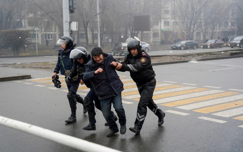 Police officers detain a demonstrator during a protest in Almaty - AP