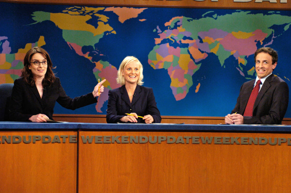 Tina Fey, Amy Poehler, and Seth Meyers sit at the "Weekend Update" desk