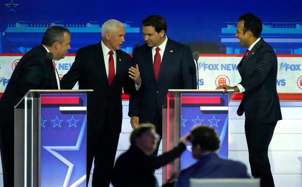 Republican presidential candidates (from left) former New Jersey governor Chris Christie, former Vice President Mike Pence Florida governor Ron DeSantis, and Biotech entrepreneur Vivek Ramaswamy joke with one another during a commercial break at Fiserv Forum during the first 2023 Republican presidential debate.