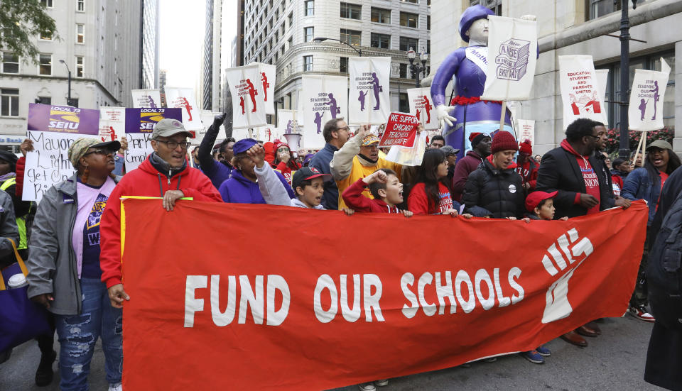 Teachers, staff and their supporters march through downtown Chicago, Monday, Oct. 14, 2019. The teachers are calling for district leaders to meet their demands on class sizes just days before a threatened strike that would affect thousands of students in the country's third-largest school district. (AP Photo/Teresa Crawford)