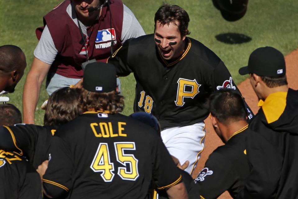 Pittsburgh Pirates' Neil Walker (18) is greeted by teammates after hitting a walk-off solo-home run off Chicago Cubs relief pitcher Carlos Villanueva during the tenth inning of a baseball game in Pittsburgh Monday, March 31, 2014. The Pirates won 1-0 in ten innings.(AP Photo/Gene J. Puskar)