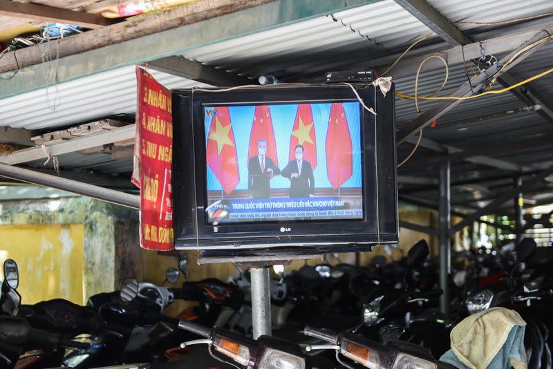A television displays news about Chinese foreign minister Wang Yi's visit to Vietnam, at a street in Hanoi
