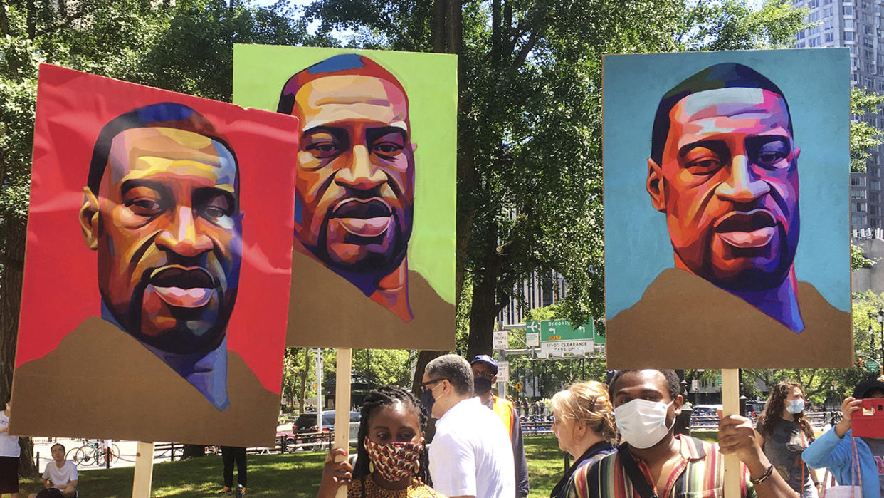 Demonstrators hold signs in lower Manhattan near City Hall on Tuesday, the one-year anniversary of George Floyd's death. (Photo by: STRF/STAR MAX/IPx 2021)