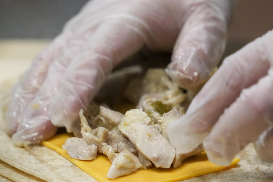 Gavino Webb prepares whole wheat pollo verde flautas for Mount Diablo High School students to try during a taste test in Concord, Calif., Friday, Jan. 13, 2023. (AP Photo/Godofredo A. Vásquez)