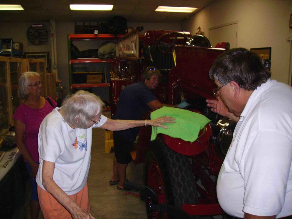 Julia Cousins Laning, left, with Earl Midlam, helps shine up Old Betsy, the city’s 1926 LaFrance Fire Engine. Cousins Laning, who turned 100 in December, died on July 16.