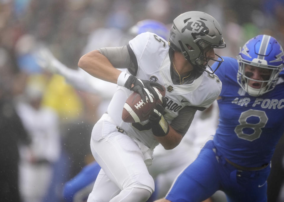 Colorado quarterback J.T. Shrout, front, is pursued by Air Force linebacker Bo Richter in the first half of an NCAA college football game Saturday, Sept. 10, 2022, at Air Force Academy, Colo. (AP Photo/David Zalubowski)