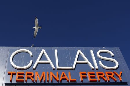 A seagull flies over a sign at the harbour of Calais, northern France, June 30, 2015. REUTERS/Vincent Kessler